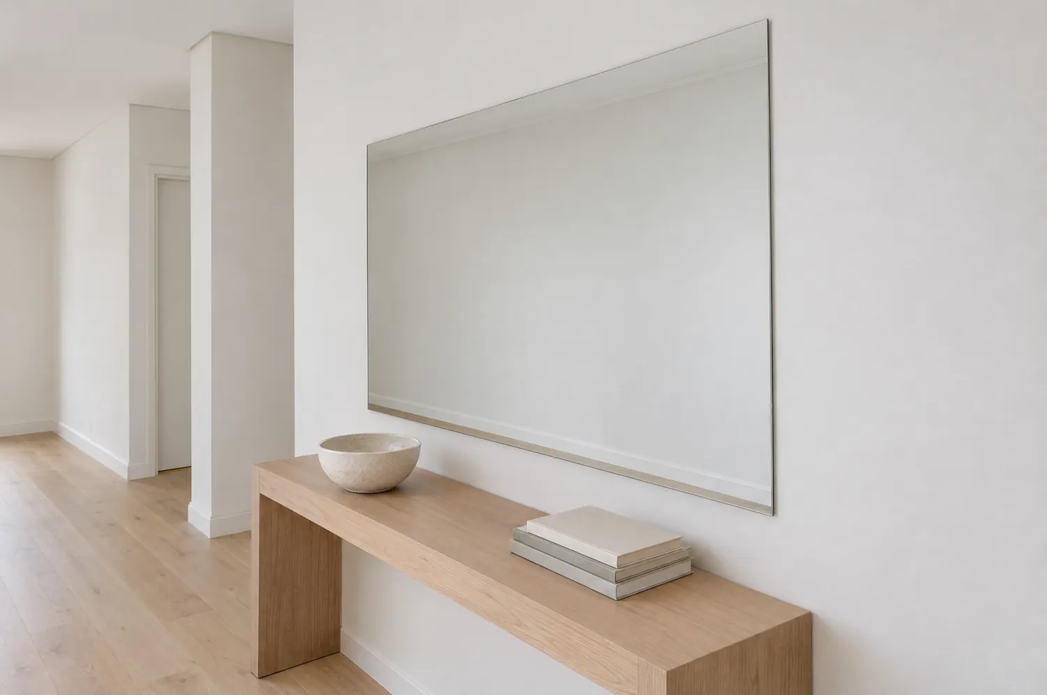 Frameless wall mirror above a hall console
